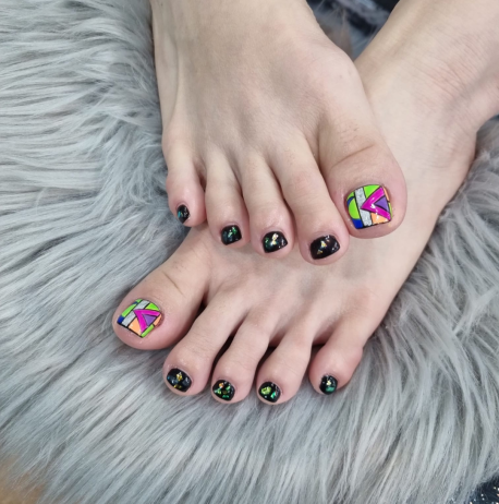 Close-up of well-groomed feet with colorful nail art on toenails